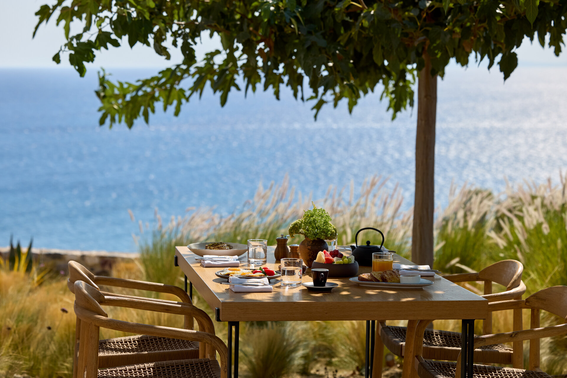Sea view breakfast served under the shade of a tree at KOIA Resort during September, one of the best times to visit Kos island.