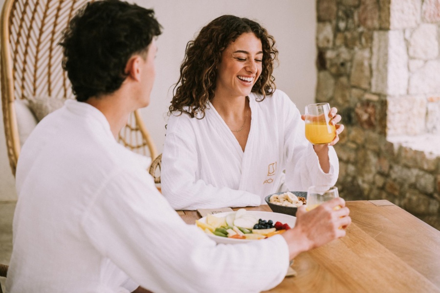 Happy couple enjoying a nourishing meal at KOIA Resort, for wellness-focused holidays in Kos island.