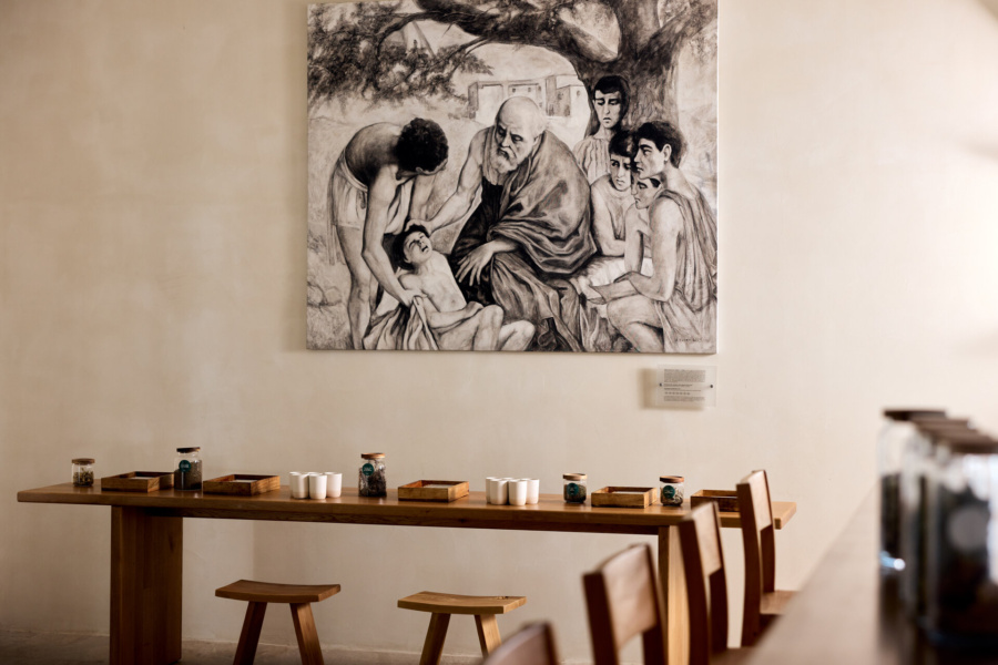 Picture of a painting at KOIA Resort, of Hippocrates of Kos examining a child patient while his students watch over under the plane tree.