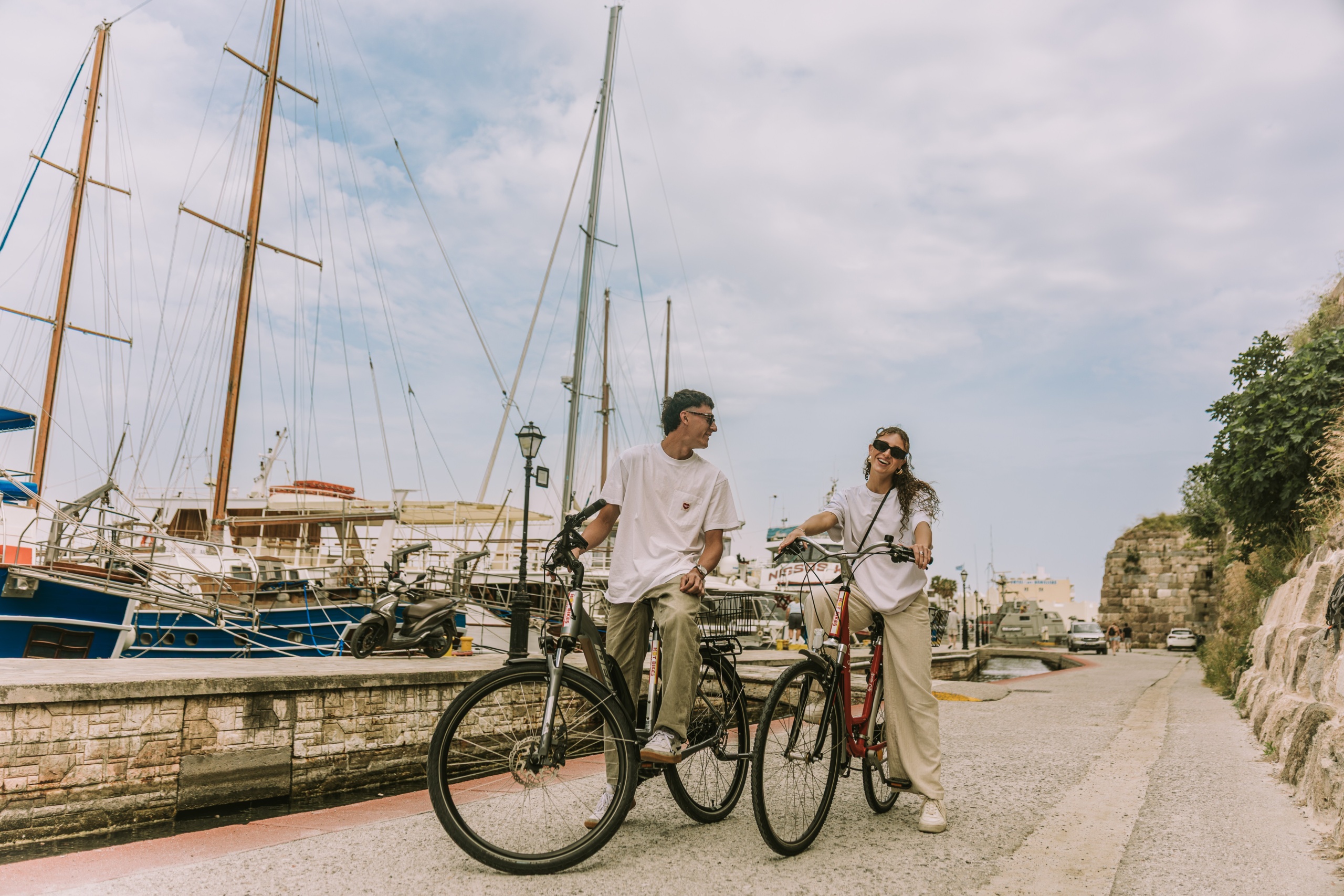Couple exploring the island on bicycles arranged by KOIA All-Suite Wellbeing Resort, the best place to stay in Kos for couples.